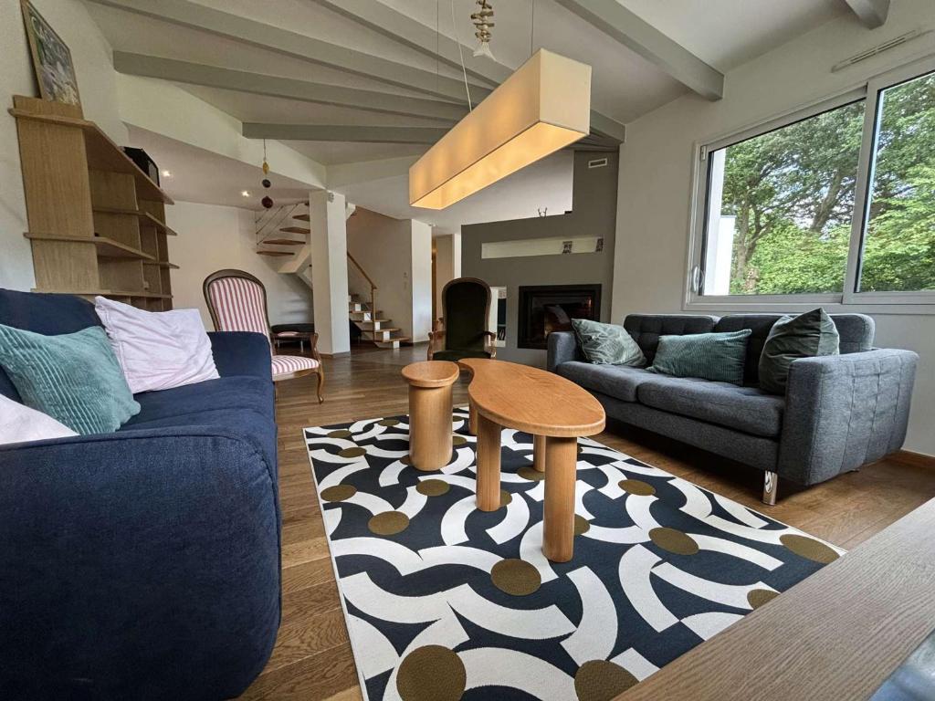 a living room with couches and a table on a rug at Maison charmante, proche plages de l'Ile-Tudy, calme garanti - FR-1-481-180 in Combrit