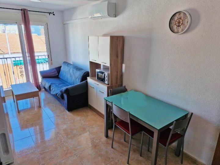 un soggiorno con tavolo blu e divano di Piso a 3 minutos de la playa a Puerto de Mazarrón