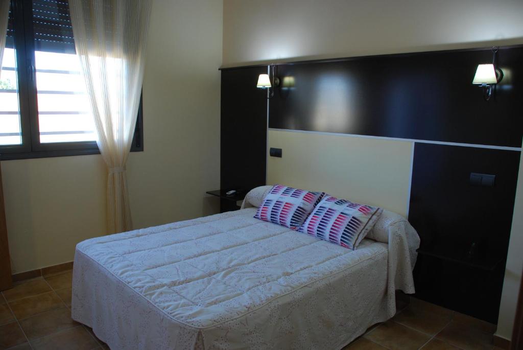 a bedroom with a bed with a black headboard at Casa Rural Virgen de las Cruces in Daimiel