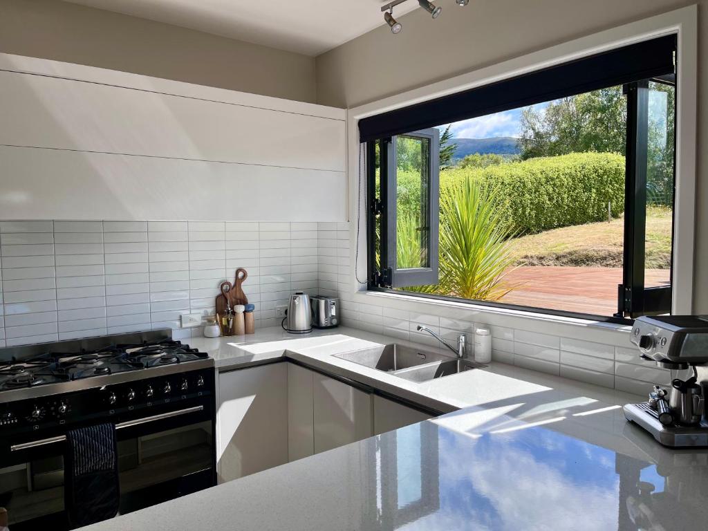 cocina con fregadero y ventana grande en Golfer's Nest, Dunedin, en Dunedin