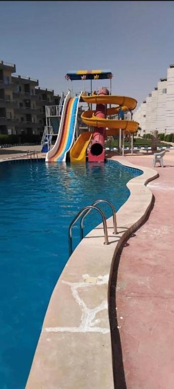 a swimming pool with a slide and a playground at تاهيتي باي الجراوله in Marsa Matruh