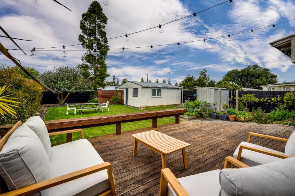 a backyard with a wooden deck with a table at Bungalow on Chambers in Napier