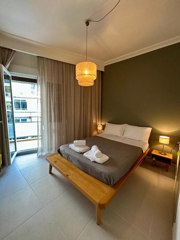 a bedroom with a large bed with two towels on it at Nagomi Centre Spot in Kavála