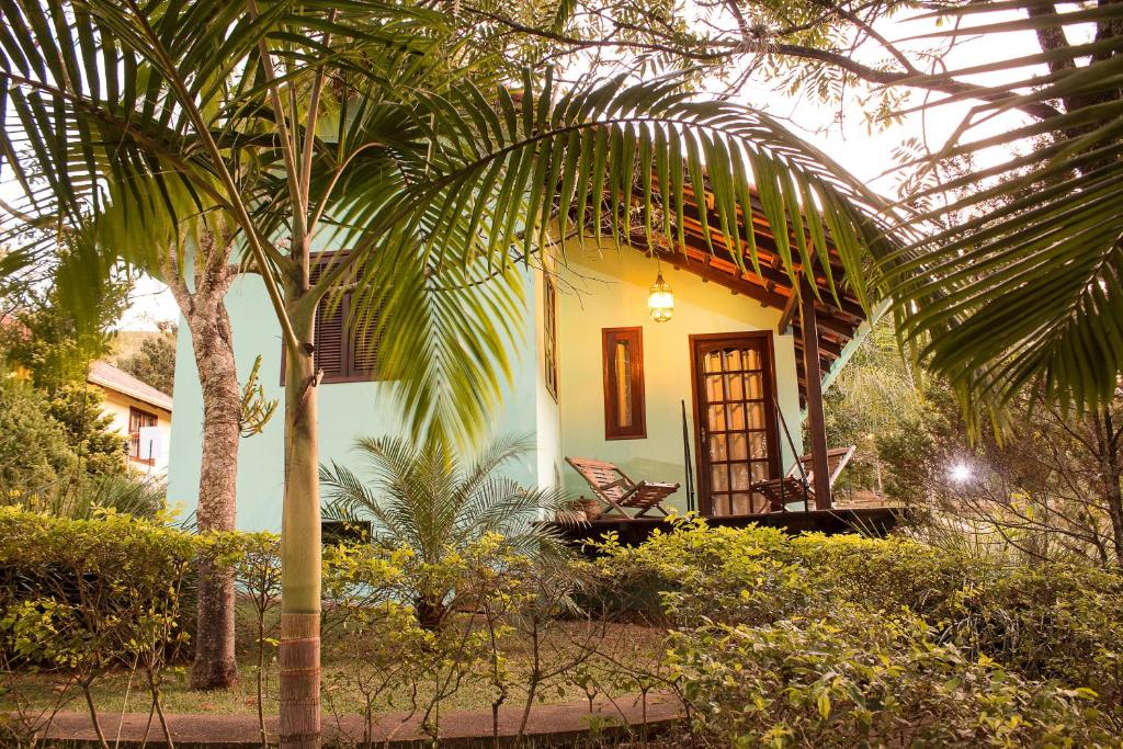 a house with a palm tree in front of it at Pousada Bonani in Itanhandu