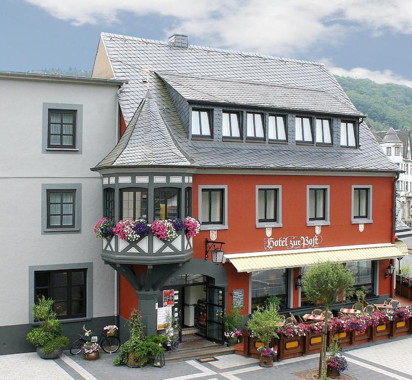 Hotel Zur Post في Waldbreitbach: مبنى عليه ابريق ورد