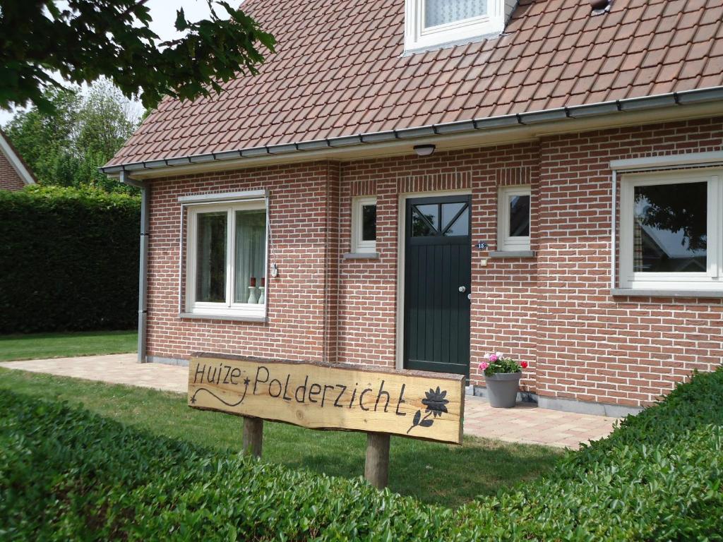 ein Haus mit einem Schild vor einem Haus in der Unterkunft Huize Polderzicht aan het Grevelingenmeer in Battenoord