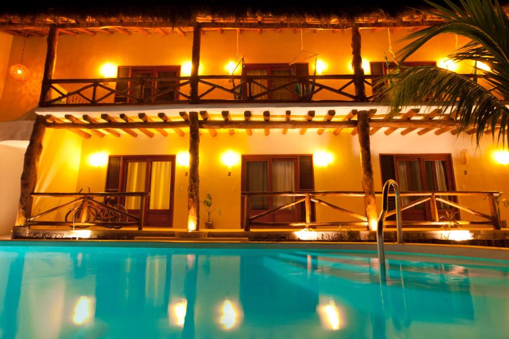 a hotel with a swimming pool in front of a building at Casa Iguana Holbox - Beachfront Hotel in Holbox Island