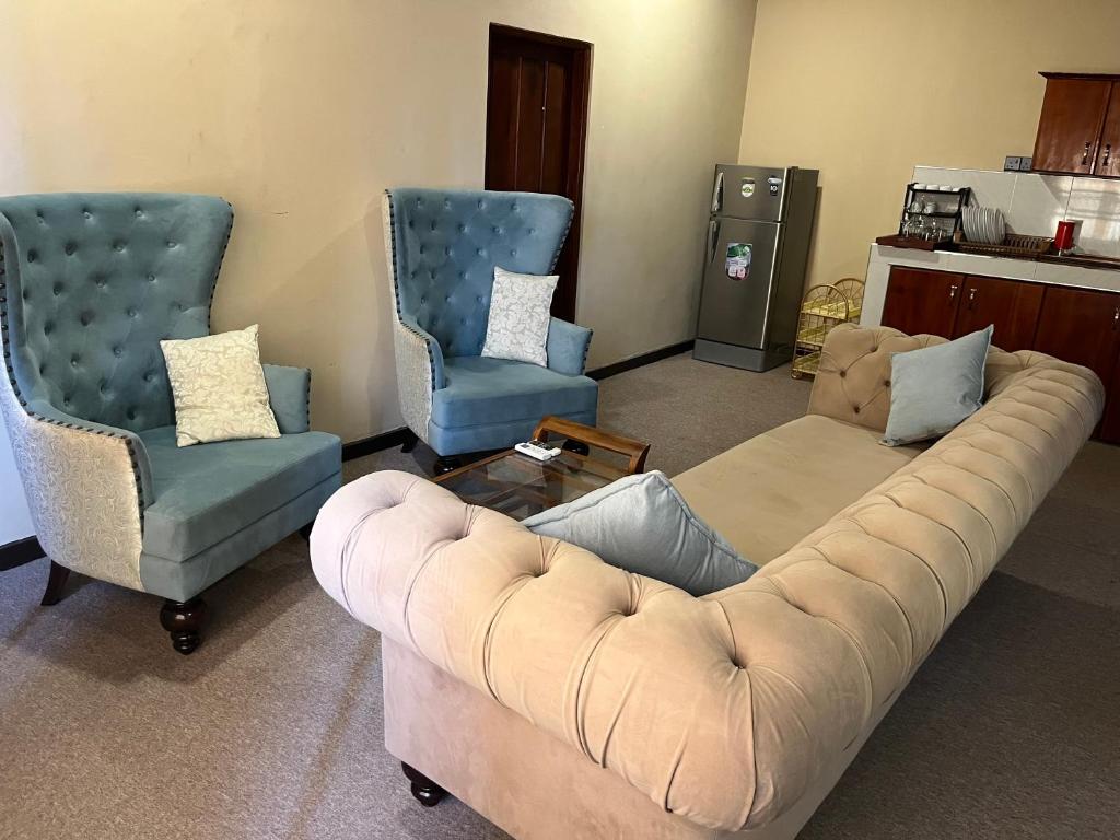 una sala de estar con un sofá y dos sillas en Sunrise Cabanas Arugam Bay, en Arugam Bay