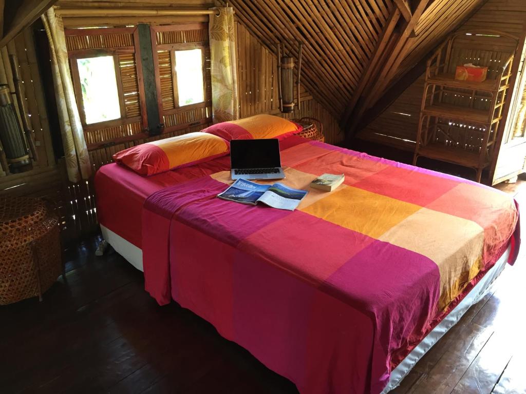 a bedroom with a bed with a laptop on it at The Village House in Puerto Princesa City