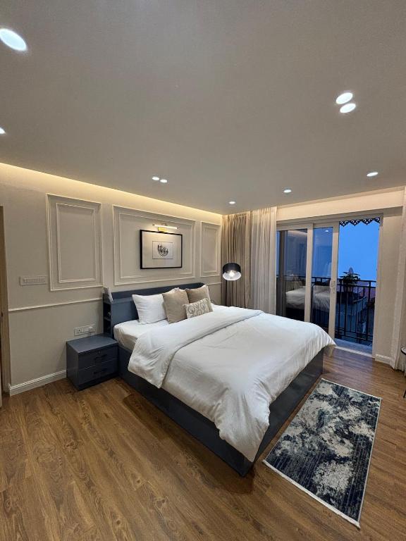 a bedroom with a large bed and a balcony at The Erina House in Darjeeling