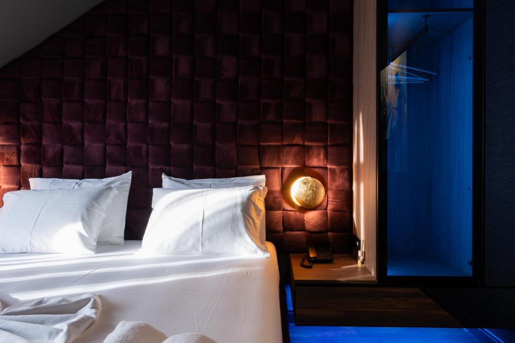 a bedroom with a white bed with a brick wall at Forest Park Hotel Krujë - Nature and Calm at Kruja's Gate in Krujë