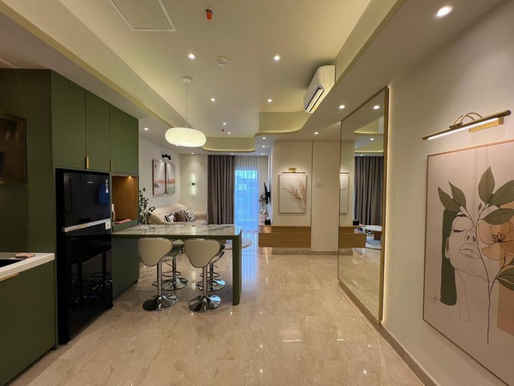 a kitchen with a table and stools in a room at Muji Style 2BR Apartment at Podomoro Medan - Cozy & Chic in Medan