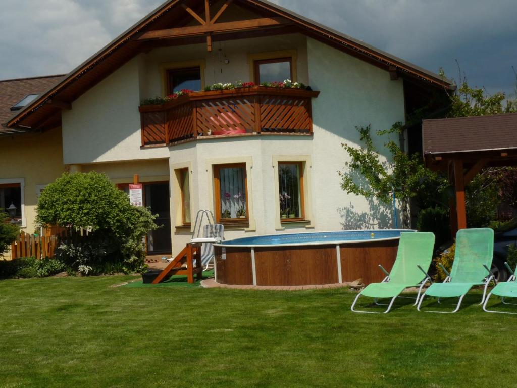 ein Haus mit einem Pool und Stühlen im Hof in der Unterkunft Privat INKA in Liptovský Mikuláš