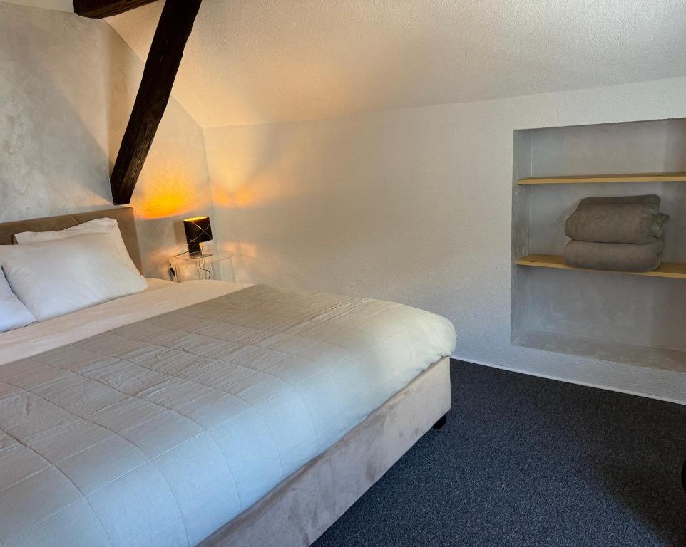a bedroom with a bed and a shelf with towels at Apartman Luma in Krapinske Toplice