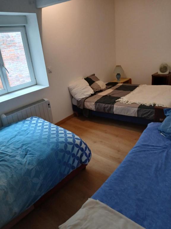 a bedroom with two beds and a window at Chic et relax familial in Montmarault