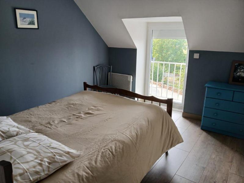 a bedroom with a bed and a blue wall at Les Hortensias in La Poultière