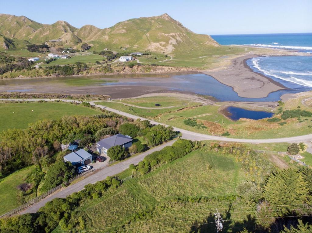 an aerial view of a farm and the ocean at Te Kōpuha in Tora