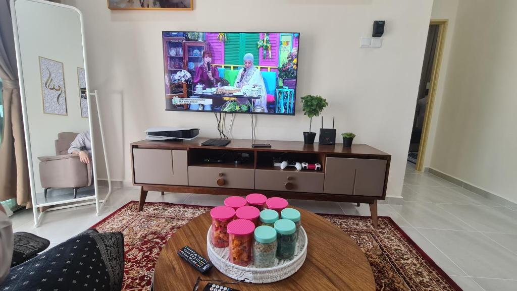 a living room with a tv and a table at Homestay cikgu Balia in Tanah Merah