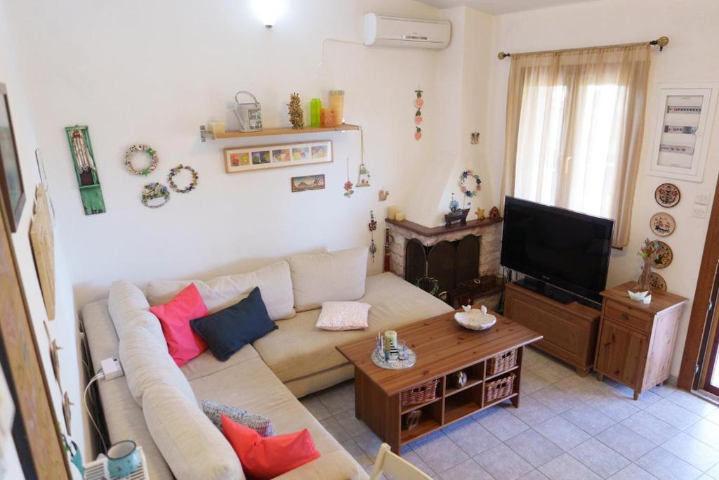 a living room with a couch and a tv at Bella Casa in Alexandroupoli