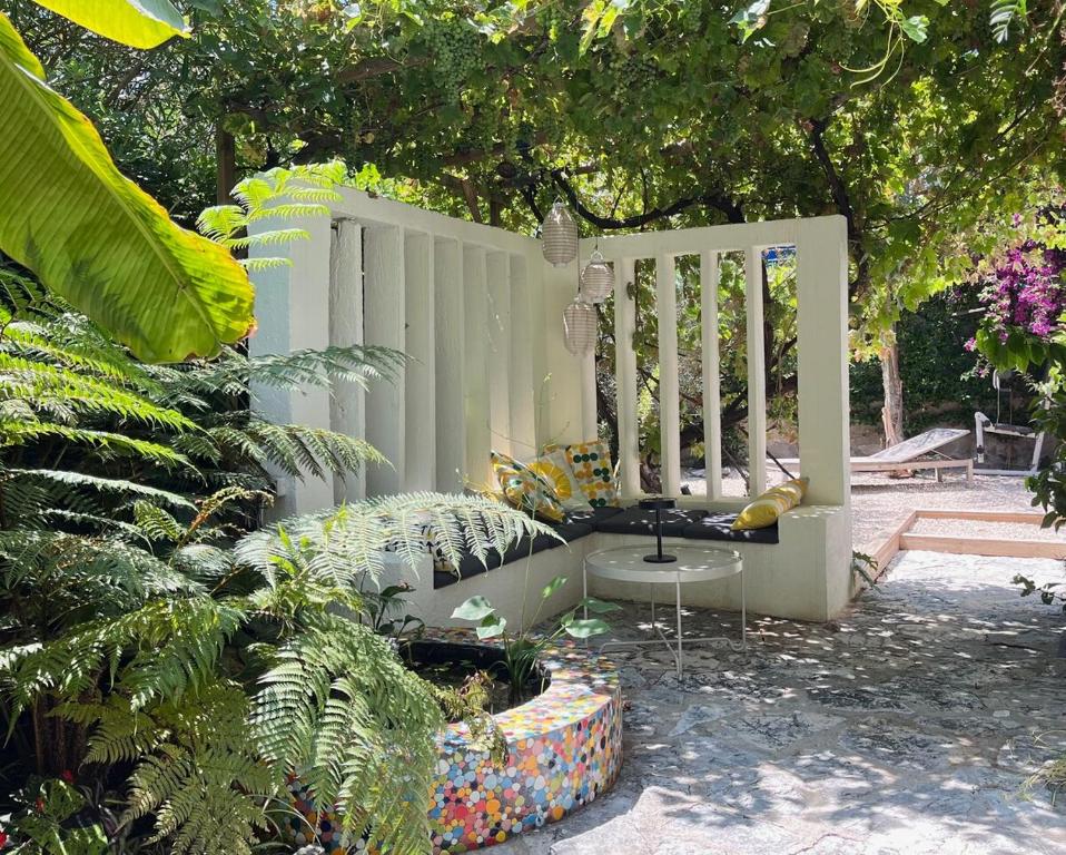 un banc blanc assis dans une cour arborée dans l'établissement Magical Villa with Secluded Garden - Beach, Port & Centre, à Vallauris