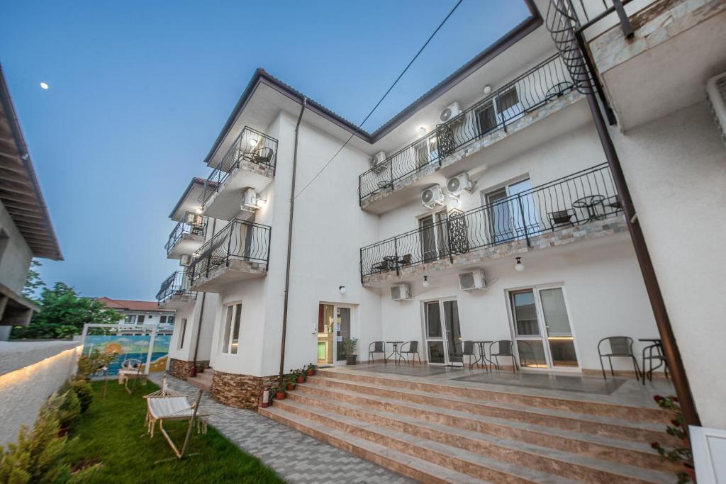 a white building with stairs and a balcony at Vila Amir Vama Veche in Vama Veche