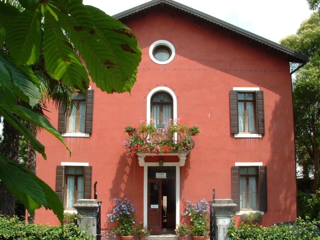 a red house with flowers in front of it at Villa Casanova in Venice-Lido