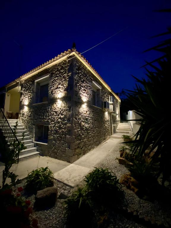 a stone house with lights on it at night at Alexas Apartment in Myrina