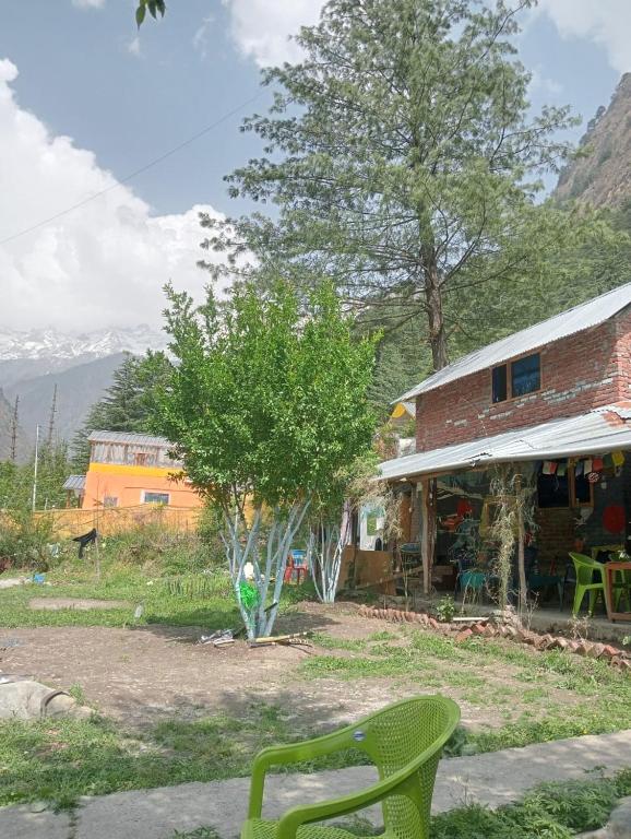 a green chair sitting in front of a building at Yeti Stay Kasol in Jhungi