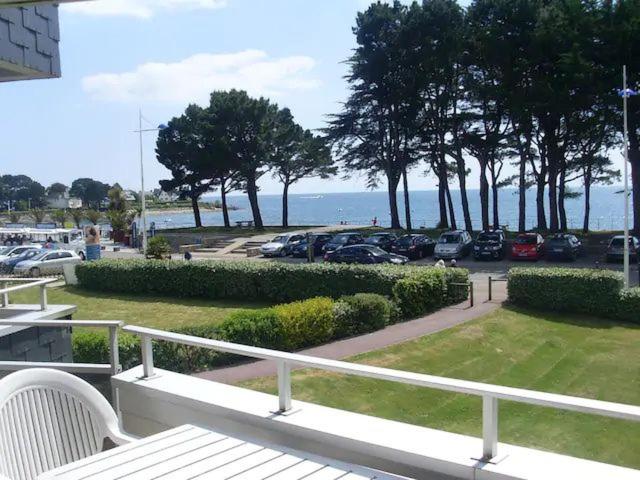 Elle comprend un balcon offrant une vue sur un parking et l'océan. dans l'établissement Vue mer panoramique et plage à 50 m, à Bénodet