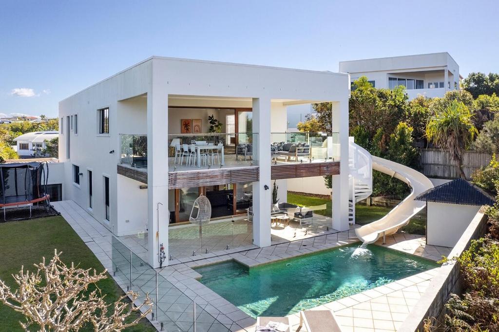 une grande maison blanche avec piscine dans l'établissement ULTIMATE NOOSA Six Bedroom Luxury with WATERSLIDE!, à Sunrise Beach