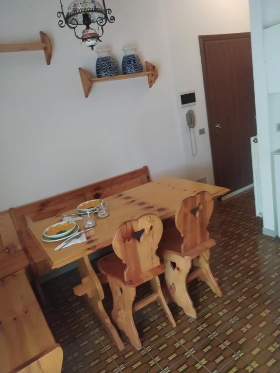 a wooden table and chairs in a room at Da Santina 23 in Frassineto