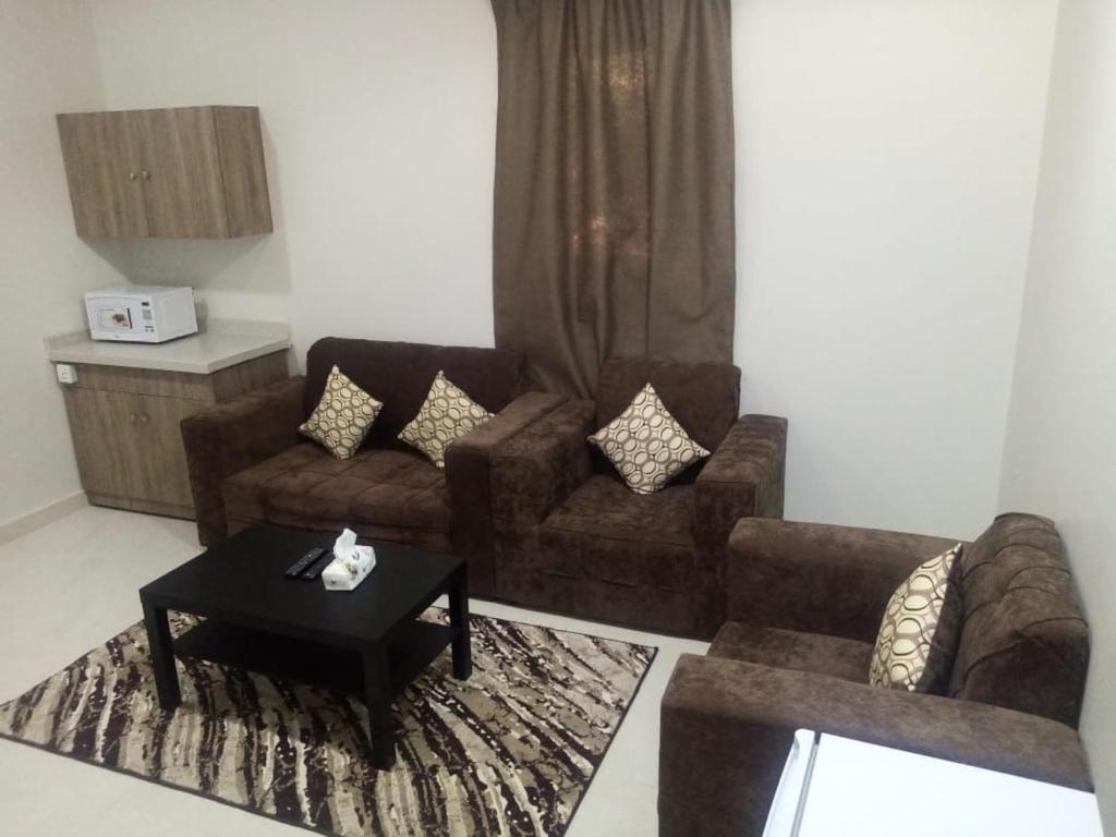 a living room with two couches and a coffee table at سمو الخير in Haradh Camp