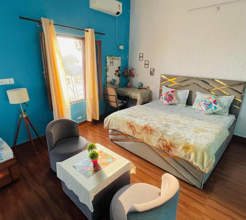 a bedroom with a bed and a chair and a table at Cozy Corner by Tulsi Homestay in Haldwāni