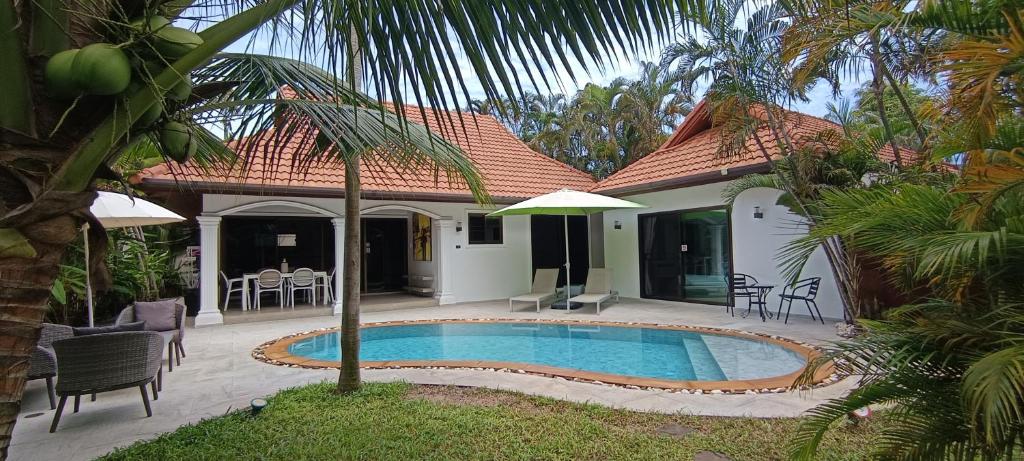 a villa with a swimming pool in front of a house at Villa Paradise Island in Rawai Beach