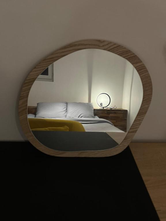 - une chambre avec un lit et un miroir rond dans l'établissement Cozy garden house, à Châteaubriant