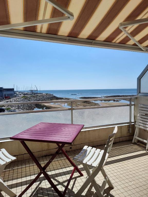 d'une table et de deux chaises sur un balcon donnant sur la plage. dans l'établissement Studio vue mer - La Turballe, à La Turballe