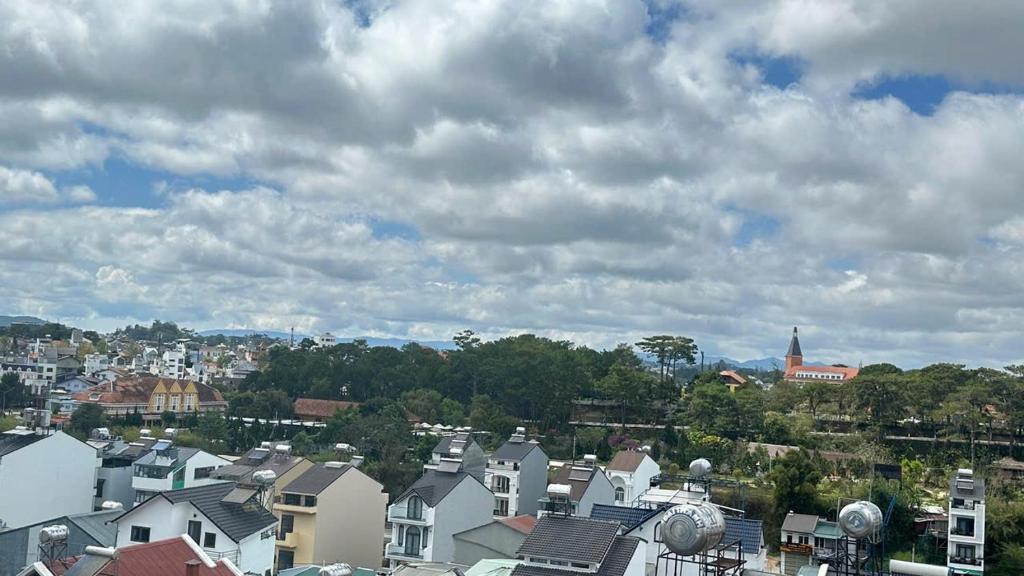 eine Gruppe von Häusern in einer Stadt unter einem wolkigen Himmel in der Unterkunft Khách Sạn in Xuan An