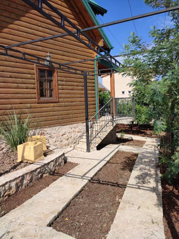 a house with a stone walkway next to a building at Lotos - vikendica 1 in Bar