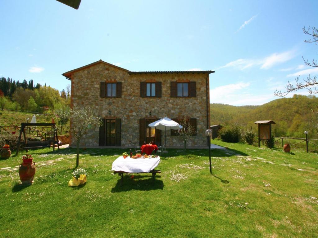 duży kamienny dom ze stołem przed nim w obiekcie Stunning Farmhouse in Passignano with Pool w mieście Passignano sul Trasimeno