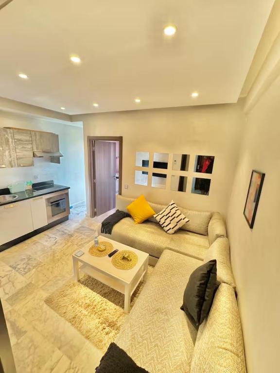 a living room with a couch and a table at Studio Cosy au Centre de Casablanca, Idéal pour Découvrir la Ville in Casablanca-Port