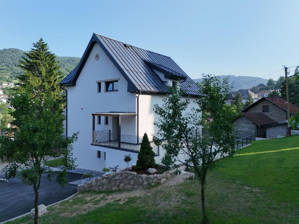 a white house with a black roof at Apartments NIM in Jajce