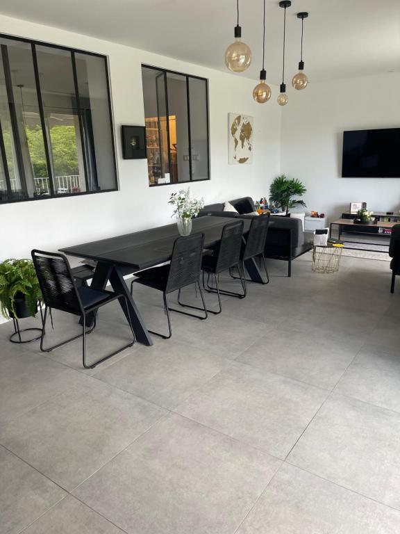 une salle à manger avec une table et des chaises noires dans l'établissement Apparemment luxueux, à Biot