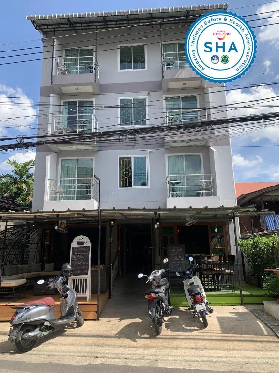 two motorcycles parked in front of a building at Chinda Boutique Hotel in Chiang Mai