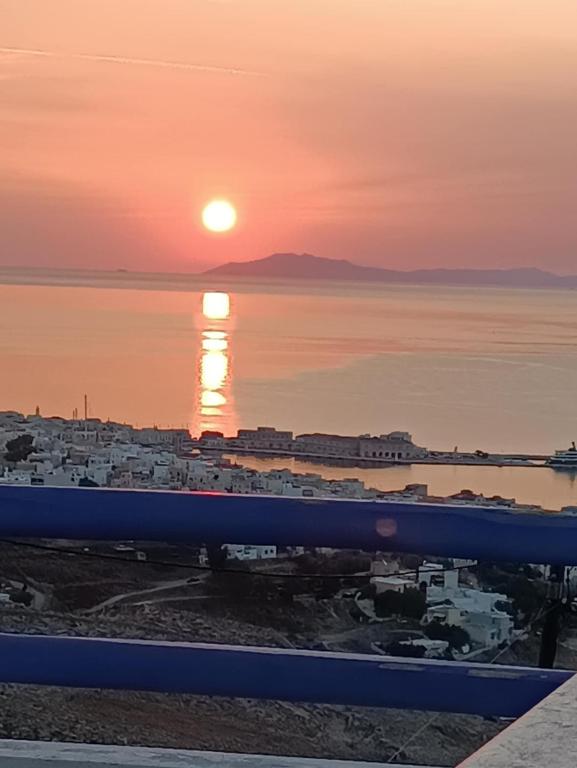 a sunset over the water with a city and the ocean at Kalliopi's Aegean View in Episkopíon