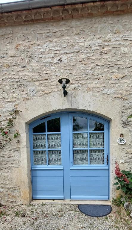 a blue door on the side of a stone building at La Grange de Rocamadour in Rocamadour