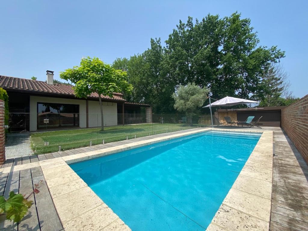 a swimming pool in front of a house at Sous les chênes de Lavaur - détente et télétravail in Lavaur
