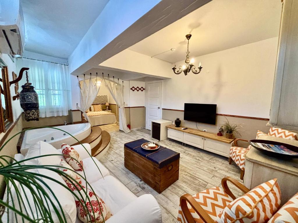 a living room with a couch and a tv at Mon Ilıca Otel in Çeşme