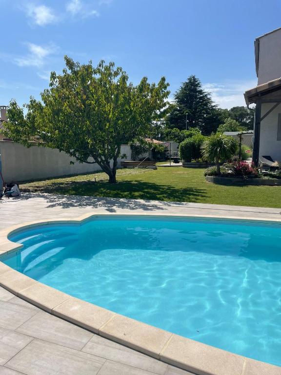 une grande piscine bleue dans une cour dans l'établissement Villa Serenita, à Villemoustaussou