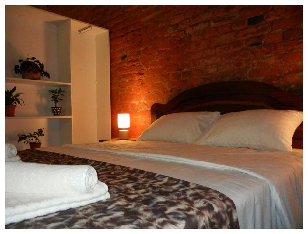 - une chambre avec un grand lit et un mur en briques dans l'établissement Tbilisi Apartment, à Tbilissi