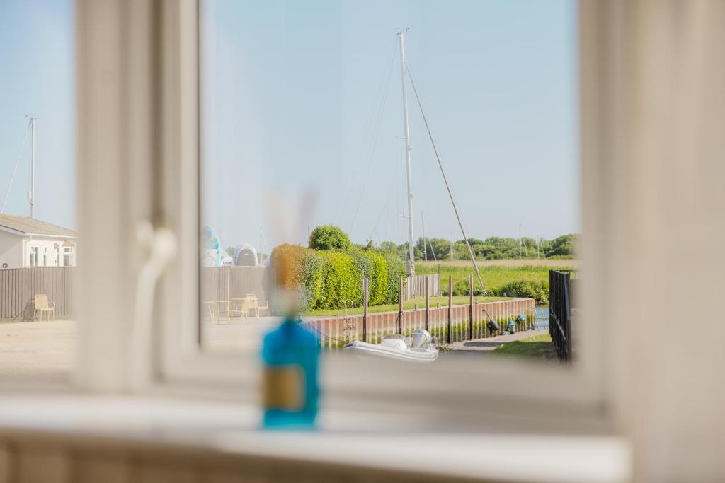 a person is looking out of a window at a boat at Restful Riverside Retreat in Christchurch